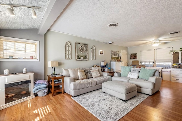 living room with visible vents, light wood-style flooring, and a healthy amount of sunlight