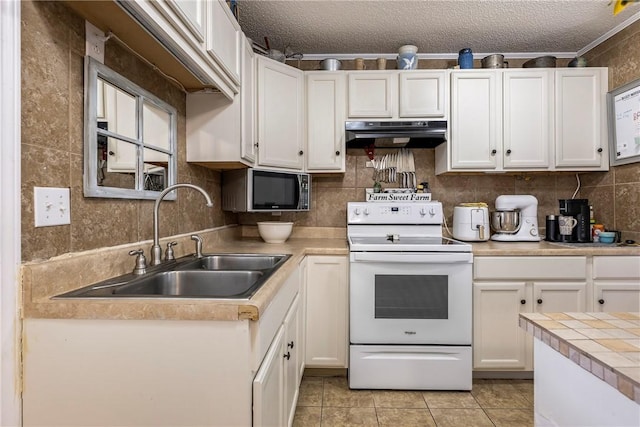 kitchen with white cabinets, electric stove, under cabinet range hood, and a sink