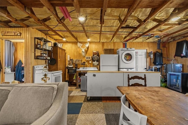 interior space with wooden walls, stacked washing maching and dryer, and freestanding refrigerator