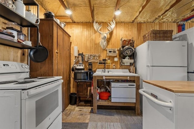 kitchen with white appliances, butcher block countertops, and wood walls