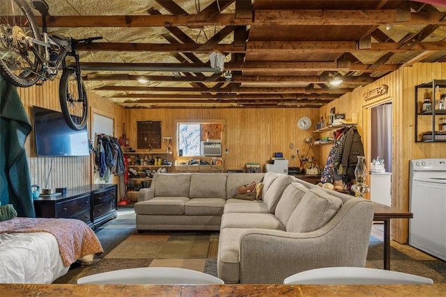 living area featuring vaulted ceiling with beams, wood walls, and washer / clothes dryer