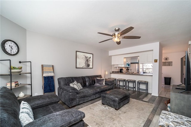 living area featuring dark wood-type flooring and a ceiling fan