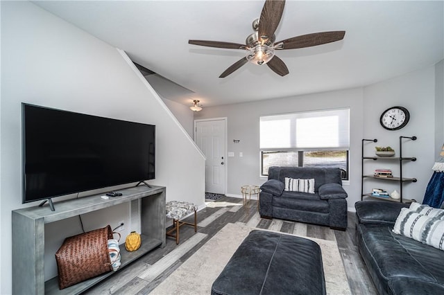 living area featuring ceiling fan, baseboards, and wood finished floors