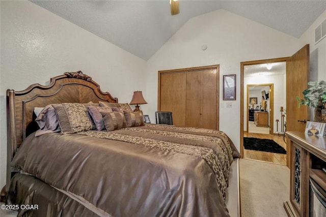 bedroom with vaulted ceiling, a closet, light wood finished floors, and ceiling fan