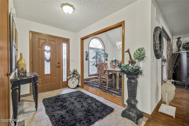 foyer entrance featuring light wood-style flooring and a textured ceiling