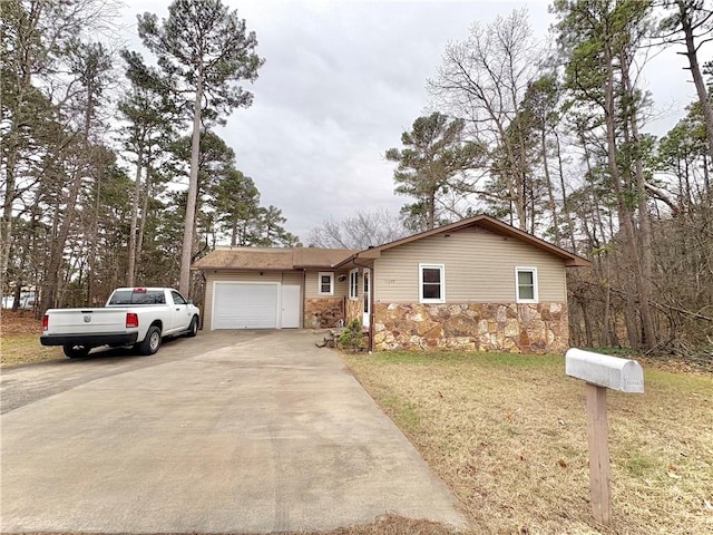 view of front facade featuring stone siding, driveway, a front yard, and a garage