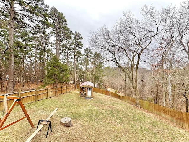 view of yard featuring an outbuilding, a storage unit, and a fenced backyard