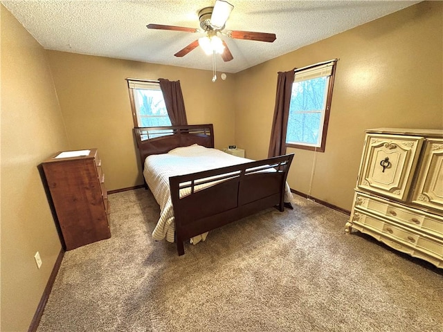 bedroom featuring light colored carpet, baseboards, and a textured ceiling