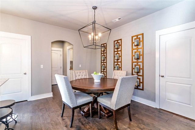 dining space featuring visible vents, dark wood-style floors, arched walkways, baseboards, and a chandelier