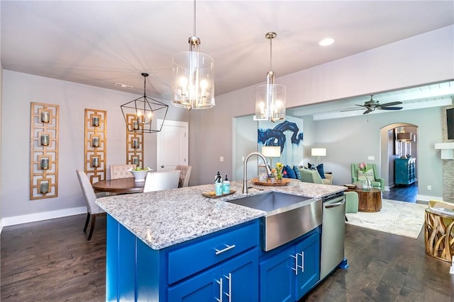 kitchen with a sink, blue cabinets, stainless steel dishwasher, and open floor plan