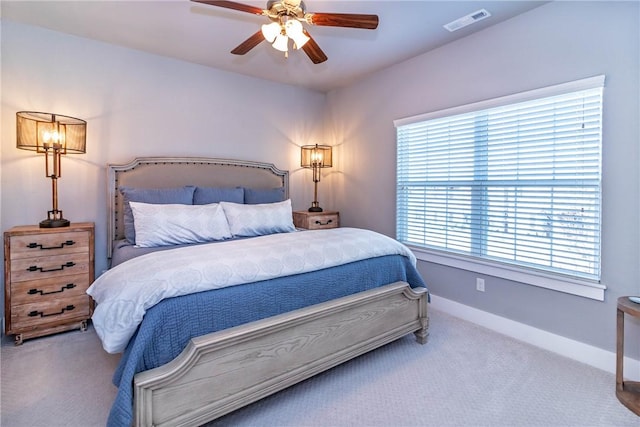 carpeted bedroom with visible vents, baseboards, and a ceiling fan