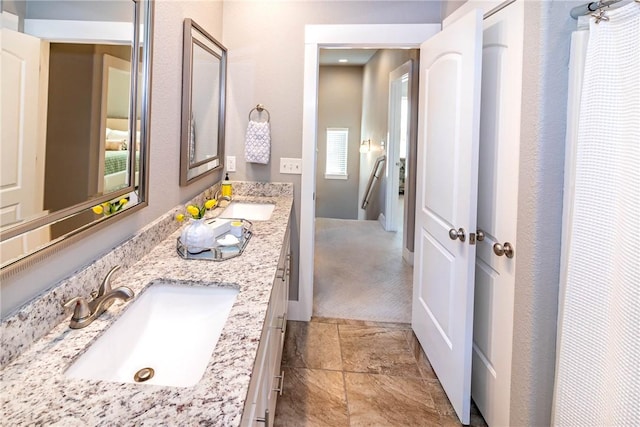 full bathroom with a sink and double vanity