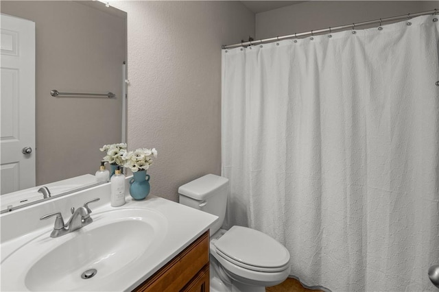 full bathroom with a shower with curtain, toilet, vanity, and a textured wall