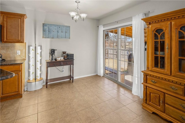 dining room with light tile patterned floors, a notable chandelier, and baseboards