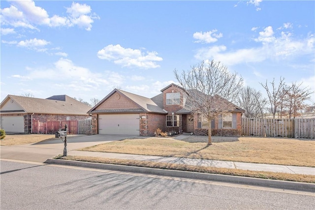 view of front of home with brick siding, fence, a front yard, a garage, and driveway