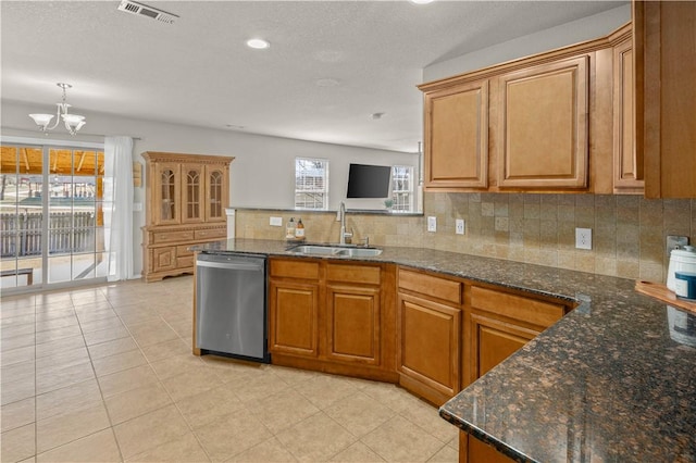 kitchen with visible vents, brown cabinets, a sink, backsplash, and dishwasher