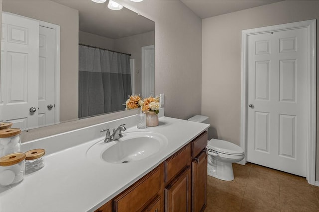 full bath featuring toilet, vanity, and tile patterned flooring