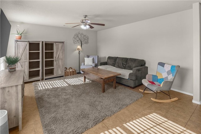 living room with baseboards, a ceiling fan, and tile patterned flooring