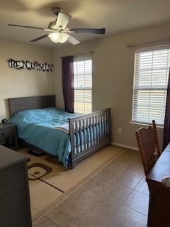 bedroom with tile patterned floors, baseboards, and a ceiling fan