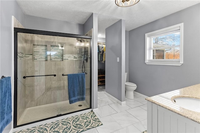 bathroom with toilet, marble finish floor, a stall shower, a textured ceiling, and baseboards