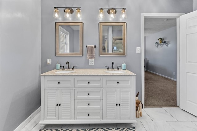 full bath featuring double vanity, baseboards, and a sink