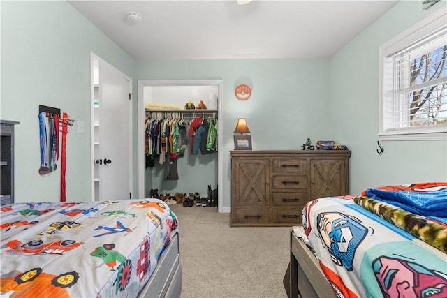 carpeted bedroom featuring a closet and a walk in closet