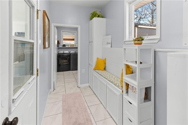 interior space featuring washing machine and clothes dryer and marble finish floor