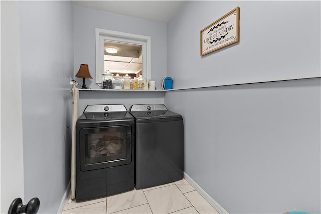 laundry area with baseboards, washing machine and dryer, and laundry area