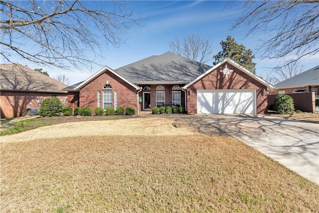 view of front facade featuring a front yard, fence, an attached garage, concrete driveway, and brick siding