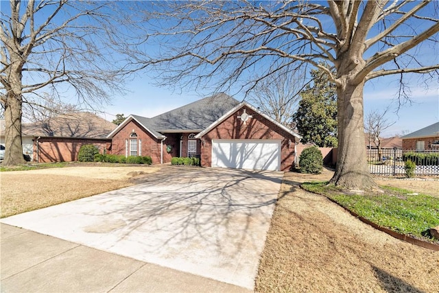 view of front of home featuring concrete driveway, a garage, fence, and brick siding