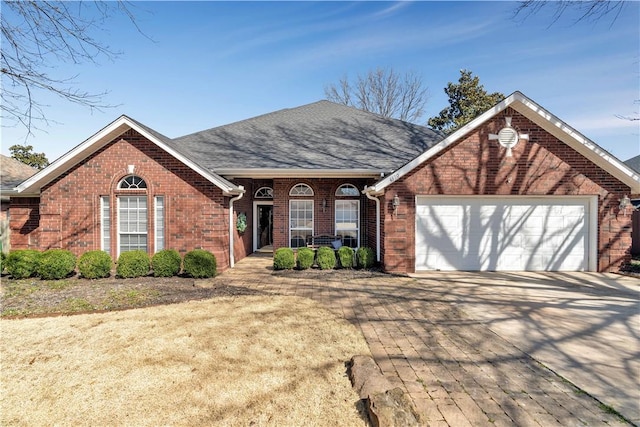 ranch-style house with an attached garage, brick siding, and driveway