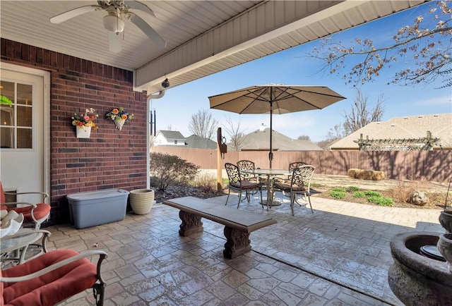 view of patio with outdoor dining area, fence, and ceiling fan