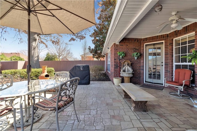 view of patio / terrace with a fenced backyard, outdoor dining space, a grill, and a ceiling fan