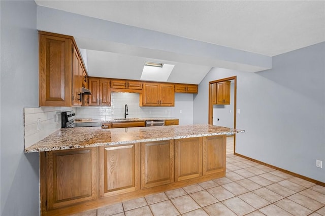 kitchen featuring a sink, light stone countertops, range with electric stovetop, and a peninsula