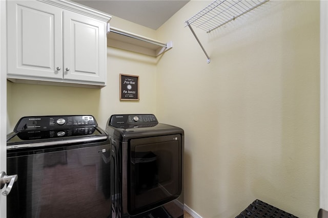 laundry room with baseboards, cabinet space, and washing machine and clothes dryer