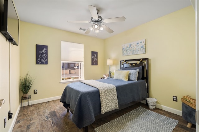 bedroom featuring ceiling fan, wood finished floors, visible vents, and baseboards