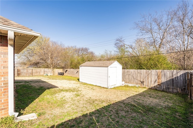 view of yard featuring a storage shed, an outbuilding, and a fenced backyard