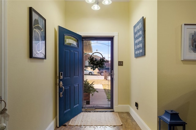 foyer entrance with wood finished floors and baseboards