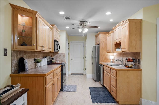 kitchen featuring baseboards, visible vents, a sink, ceiling fan, and stainless steel appliances