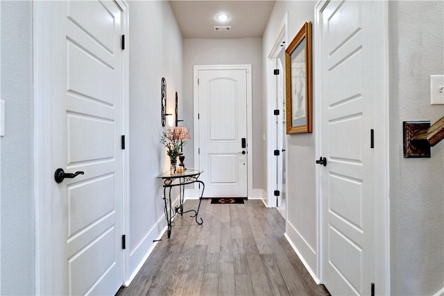 interior space with visible vents, wood finished floors, and baseboards