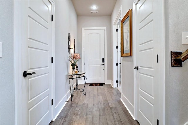 hall featuring wood finished floors and baseboards