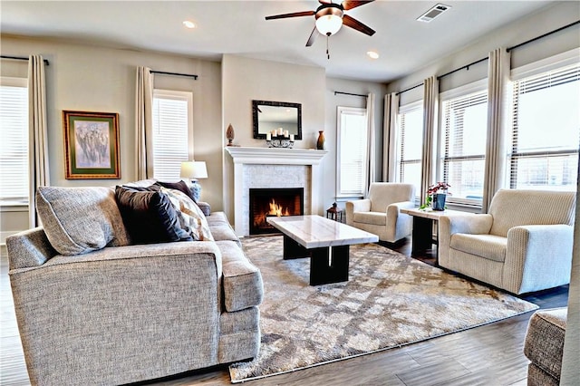 living area featuring visible vents, ceiling fan, a lit fireplace, recessed lighting, and wood finished floors