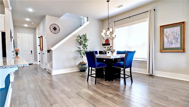 dining area with visible vents, baseboards, light wood finished floors, recessed lighting, and a chandelier