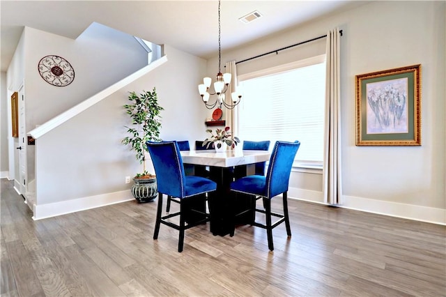 dining room with an inviting chandelier, wood finished floors, visible vents, and baseboards