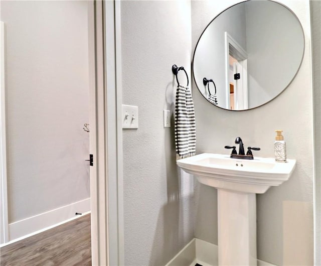 bathroom with wood finished floors and baseboards
