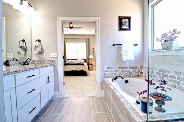 ensuite bathroom with a garden tub, ensuite bath, vanity, and a ceiling fan