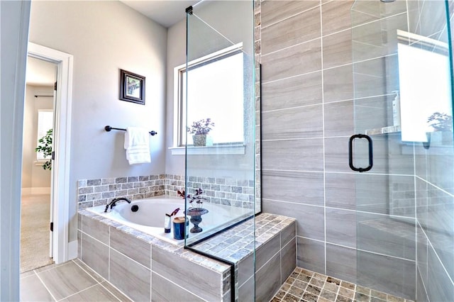 full bathroom featuring tile patterned flooring, a bath, and a stall shower