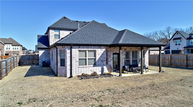 rear view of property with a shingled roof, central AC, a lawn, a fenced backyard, and a patio area