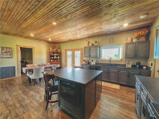 kitchen with a sink, dark countertops, and wooden ceiling