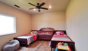 bedroom featuring visible vents, wood finished floors, and a ceiling fan